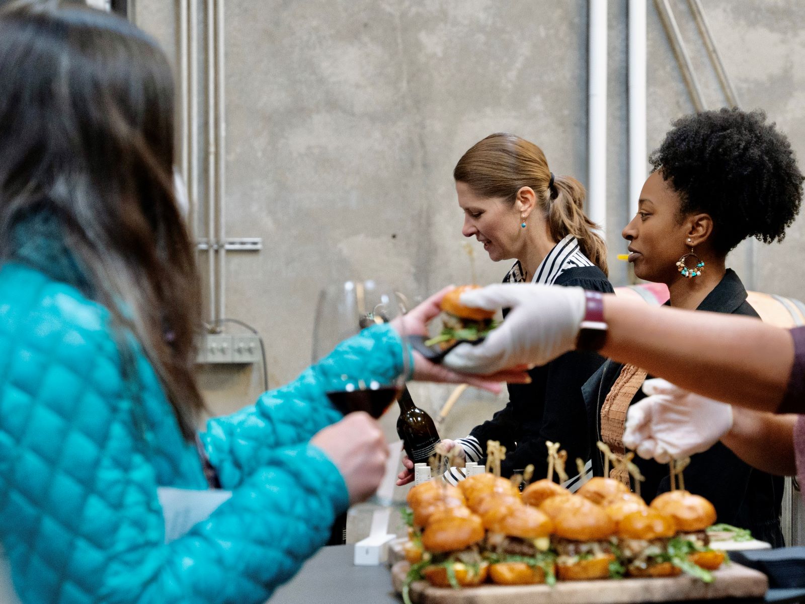 Woodinville winery event coordinator hands delicious food to wine club member.